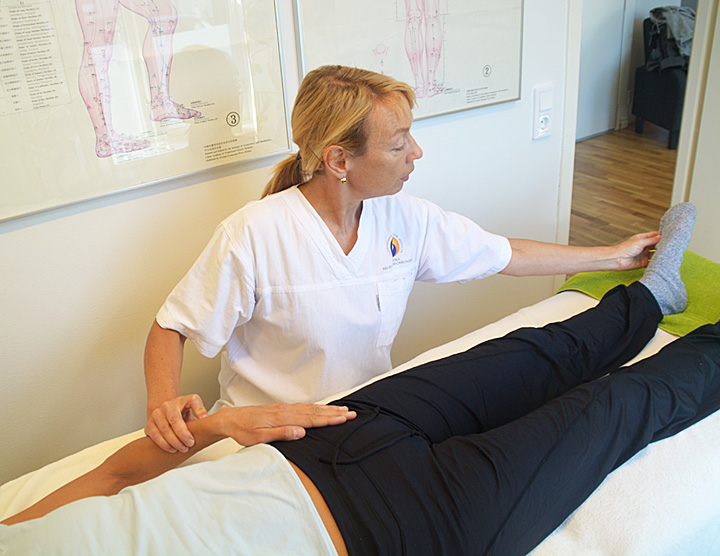 Akupunktören Karin Eringskog Tauer behandlar en patient på en massagebänk.